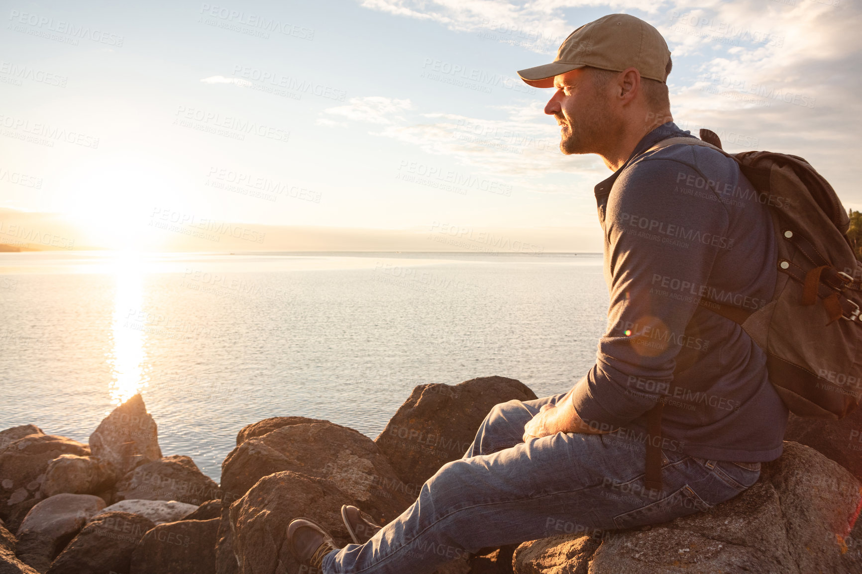 Buy stock photo Shot of a man looking at the ocean while out hiking