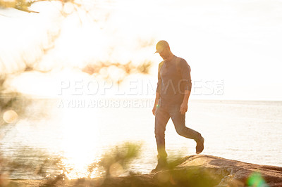 Buy stock photo Shot of a man wearing his backpack while out for a hike on a coastal trail