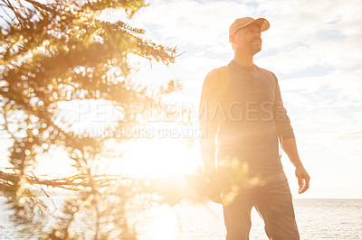 Buy stock photo Shot of a man wearing his backpack while out for a hike on a coastal trail