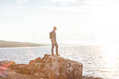 Buy stock photo Shot of a man wearing his backpack while out for a hike on a coastal trail