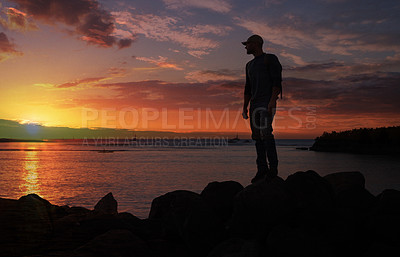 Buy stock photo Shot of a man wearing his backpack while out for a hike on a coastal trail