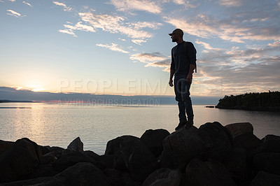 Buy stock photo Shot of a man wearing his backpack while out for a hike on a coastal trail