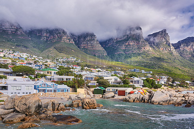 Buy stock photo Landscape view of a seaside town along the mountain on a cloudy day in Cape Town, South Africa. Scenic view of a quiet and secluded residential area on the coast for tourists and holidays in summer