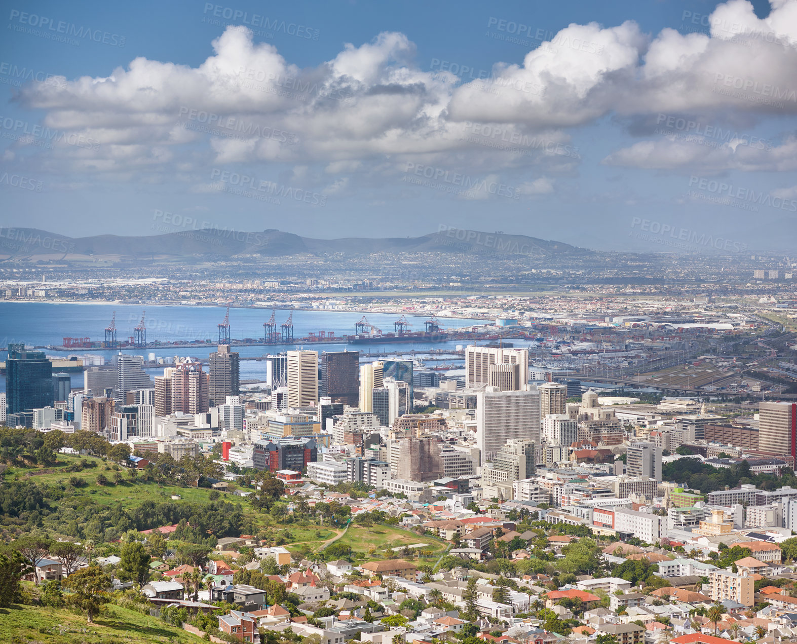 Buy stock photo Landscape of buildings in an urban town with greenery along the mountain and sea. Copy space with views from Signal Hill in Cape Town, South Africa of a cloudy blue sky over a beautiful coastal city