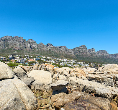 Buy stock photo Twelve Apostles at Table Mountain in Cape Town against a clear blue sky background on a sunny day with copy space. View of a peaceful suburb surrounded by scenic mountain landscape and beach boulders