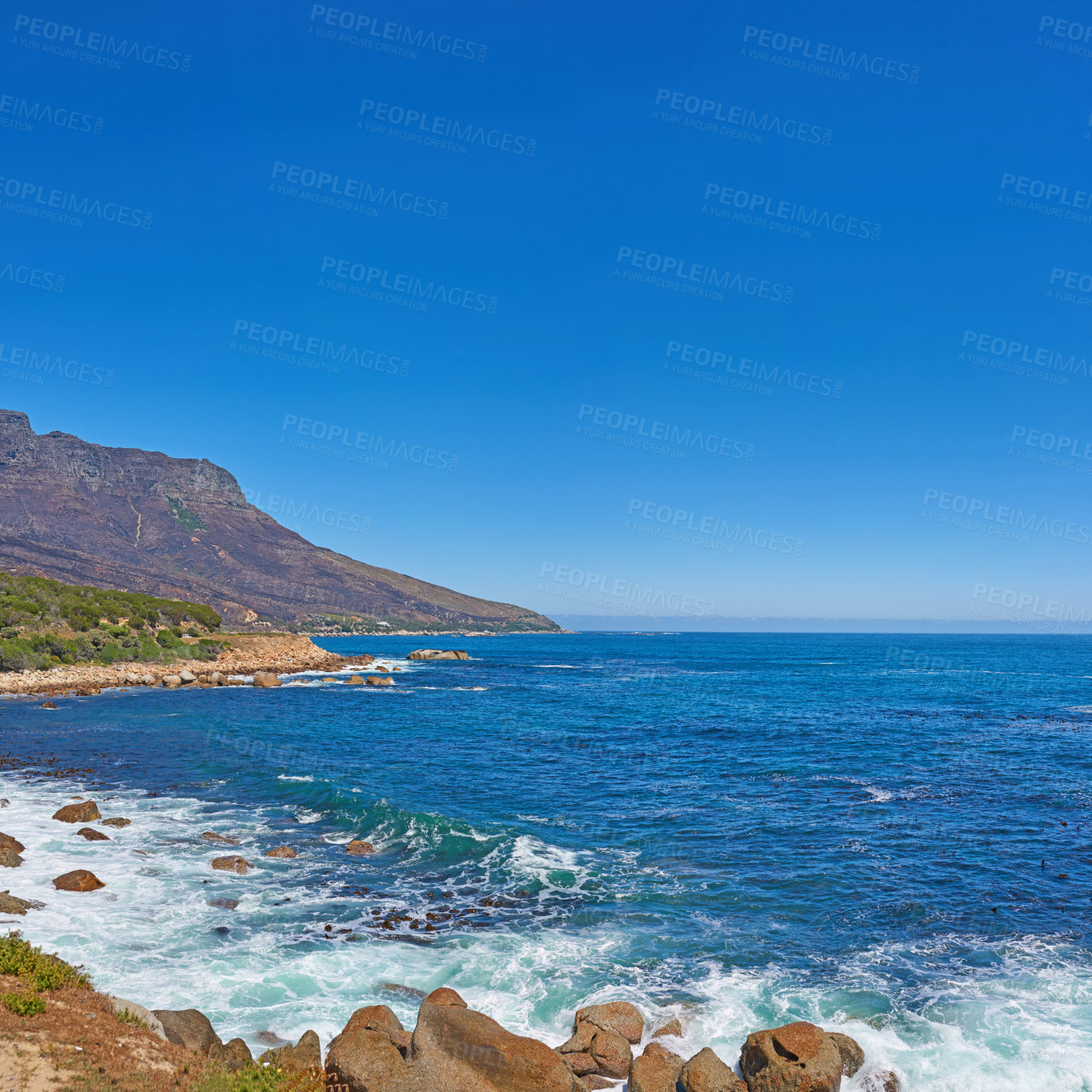 Buy stock photo Breathtaking ocean stretching across the horizon. Copy space at sea with blue sky background and rocky mountain coast in Cape Town, South Africa with scenic landscape for a relaxing summer holiday. 