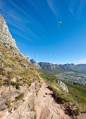 Buy stock photo Paragliding from Lions Head with a beautiful view of Table Mountain in Cape Town, South Africa. Lush green trees growing in harmony on rocky terrain. Tourist attraction for adventurous explorers
