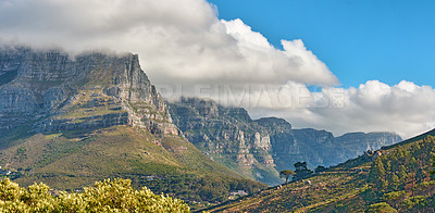 Buy stock photo Landscape banner view of a mountain with clouds rolling over in a blue sky in summer. Copyspace, scenic and panoramic view of a natural environment in the countryside. Scenery of hills and nature 