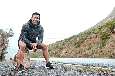 Buy stock photo Portrait of a sporty young man taking a break while exercising outdoors