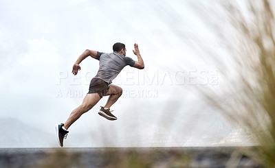 Buy stock photo Rearview shot of a sporty young man running outdoors