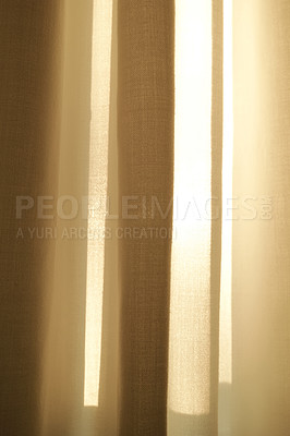 Buy stock photo Closed linen curtains hanging on window on a sunny day inside a modern home. Shadow and sunlight shining through cream cotton or beige fabric for interior decoration and copy space background