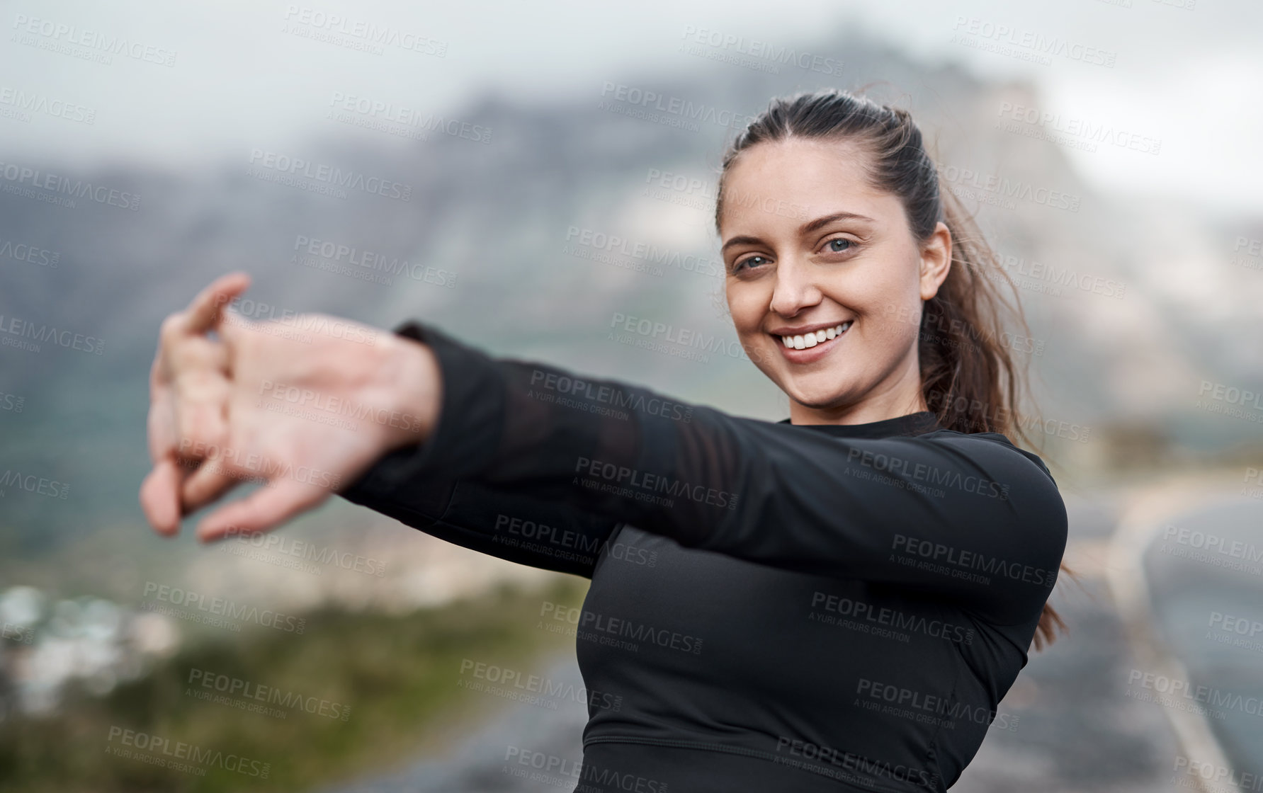 Buy stock photo Cropped portrait of an attractive young woman stretching before exercising outdoors alone