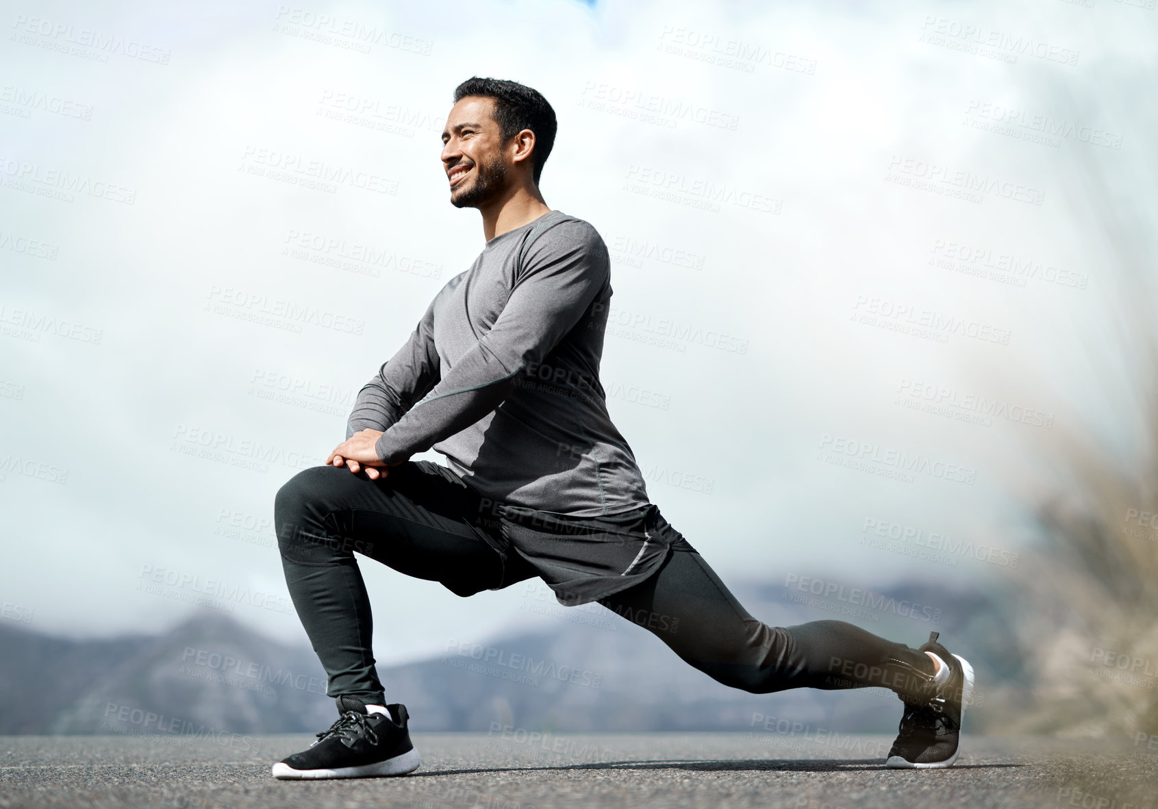 Buy stock photo Full length shot of a handsome young man stretching before exercising outdoors alone