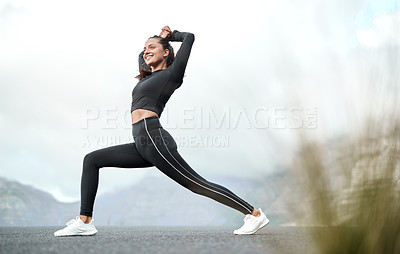 Buy stock photo Full length shot of an attractive young woman stretching before exercising outdoors alone