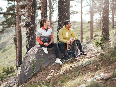 Buy stock photo Full length shot of two young athletes sitting together after a morning run through the woods