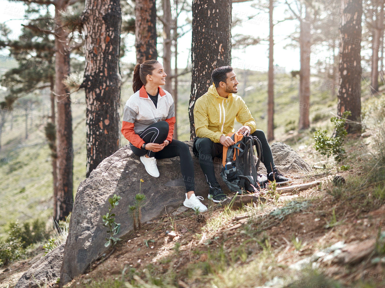 Buy stock photo Full length shot of two young athletes sitting together after a morning run through the woods