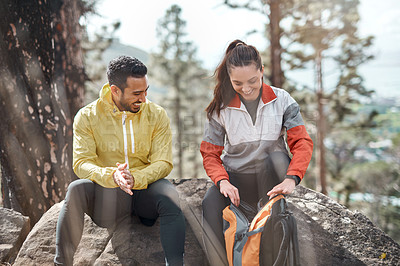 Buy stock photo Cropped shot of two young athletes sitting together after a morning run through the woods