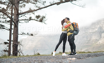 Buy stock photo Full length shot of two young athletes hugging each other while on a hike outdoors