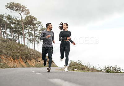 Buy stock photo Full length shot of two young athletes bonding together during a run outdoors