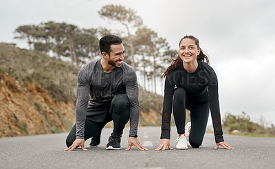 Buy stock photo Full length shot of two young athletes crouched down in a starters position before exercising outside