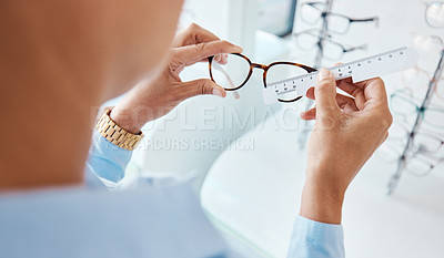 Buy stock photo Optician or optometrist hands measuring and preparing pair of glasses and frame with optic ruler tool. Eye doctor or ophthalmologist determines visual or vision lens size using special eyewear scale.