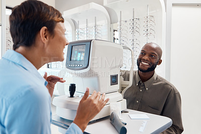 Buy stock photo Shot of an optometrist examining her patient’s eyes with an autorefractor