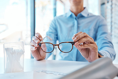 Buy stock photo Shot of a woman buying a new pair of glasses at an optometrist store