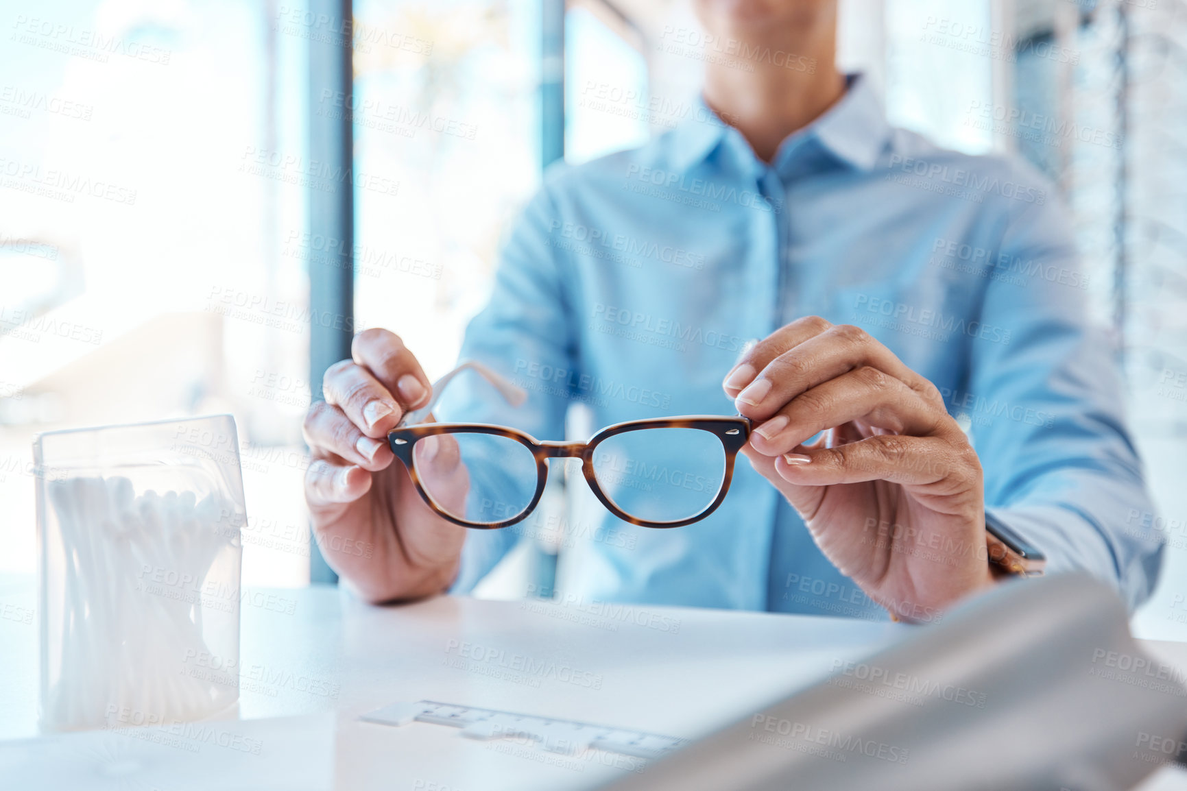 Buy stock photo Shot of a woman buying a new pair of glasses at an optometrist store