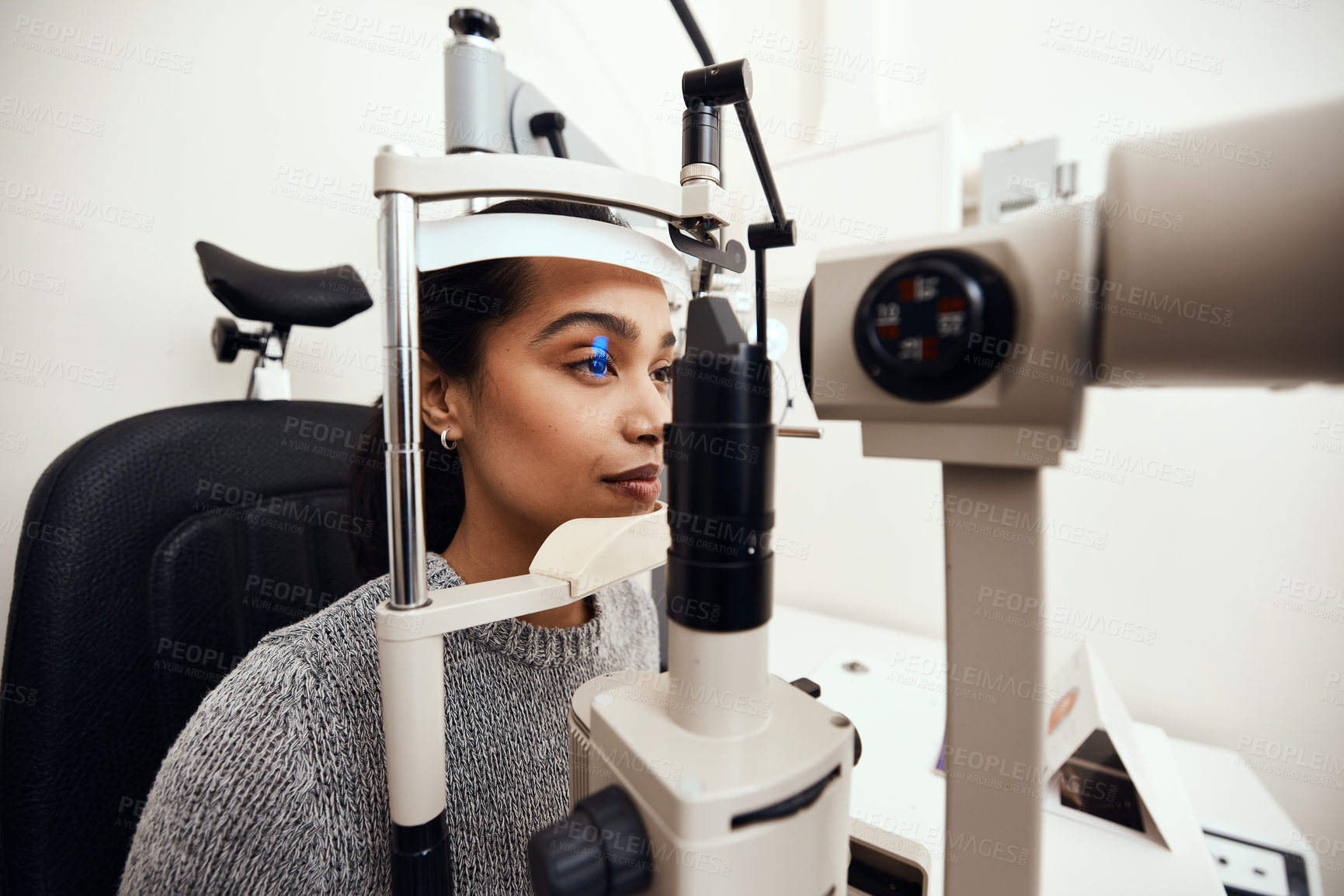 Buy stock photo Shot of a young woman getting her eye’s examined with a slit lamp