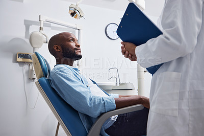 Buy stock photo Shot of a young man having a consultation with his dentist