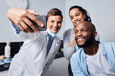 Buy stock photo Shot of a young woman taking selfies with her patient after his dental procedure