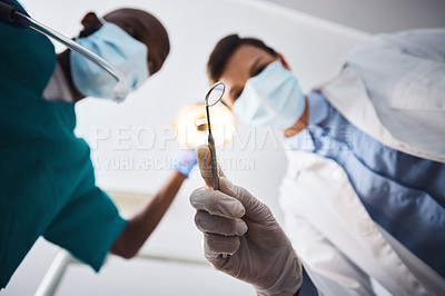 Buy stock photo Low angle shot of two dentists getting ready to perform a procedure on a patient