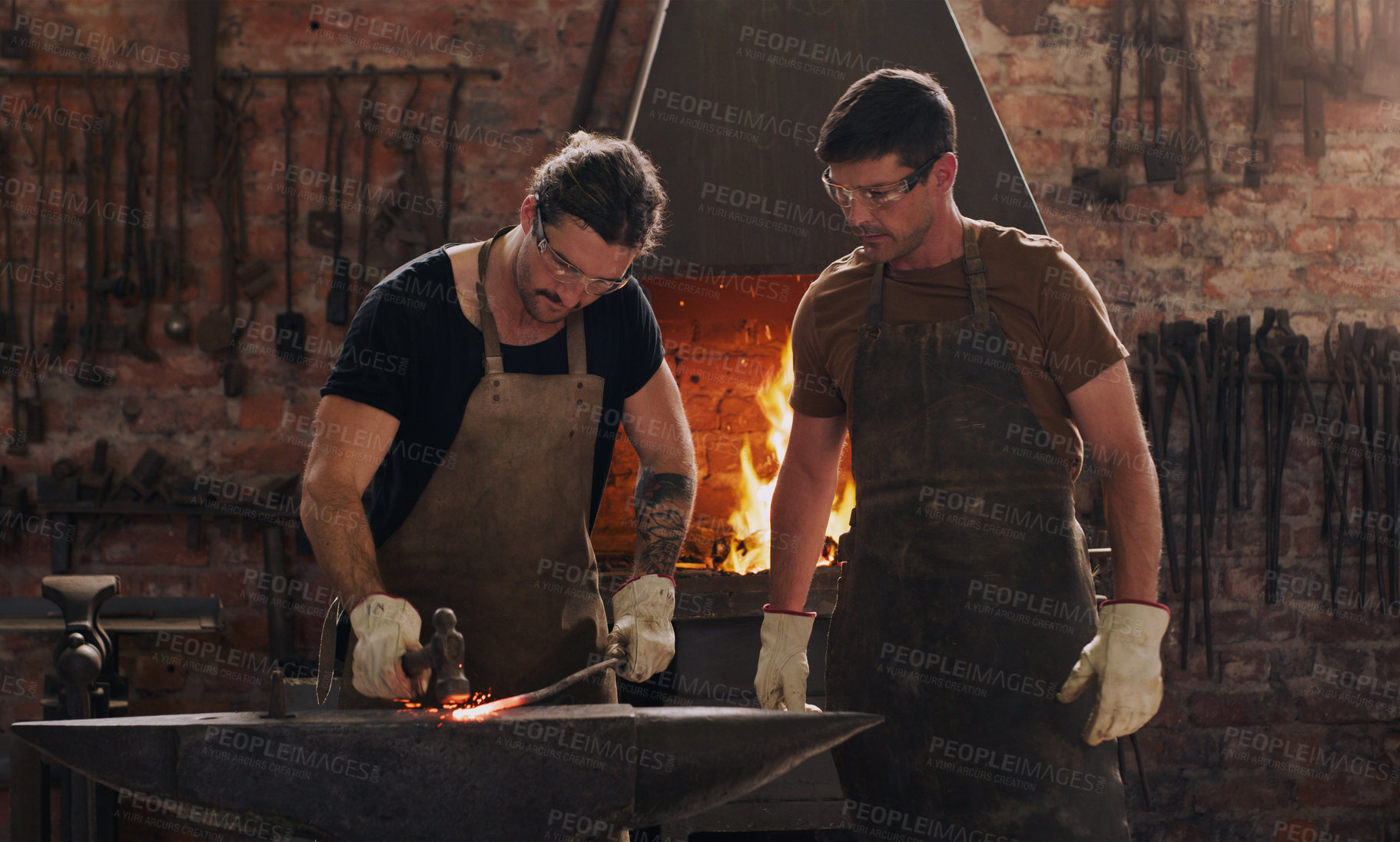 Buy stock photo Shot of two metal workers working together in a workshop