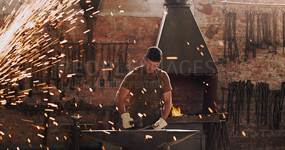 Buy stock photo Hammer, anvil and sparks with a man at work in a forge for metal work manufacturing or production. Industry, welding and trade with a male blacksmith working in a factory, plant or industrial foundry