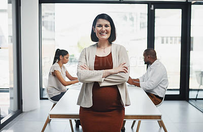 Buy stock photo Portrait of a confident pregnant businesswoman having a team meeting in a modern office