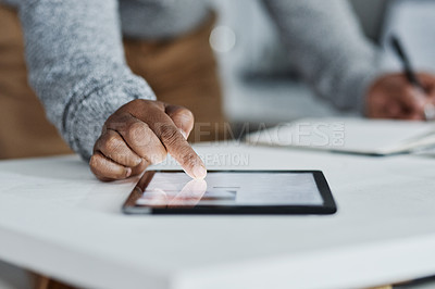 Buy stock photo Cropped shot of an unrecognizable businessman sitting alone in the office and using a tablet