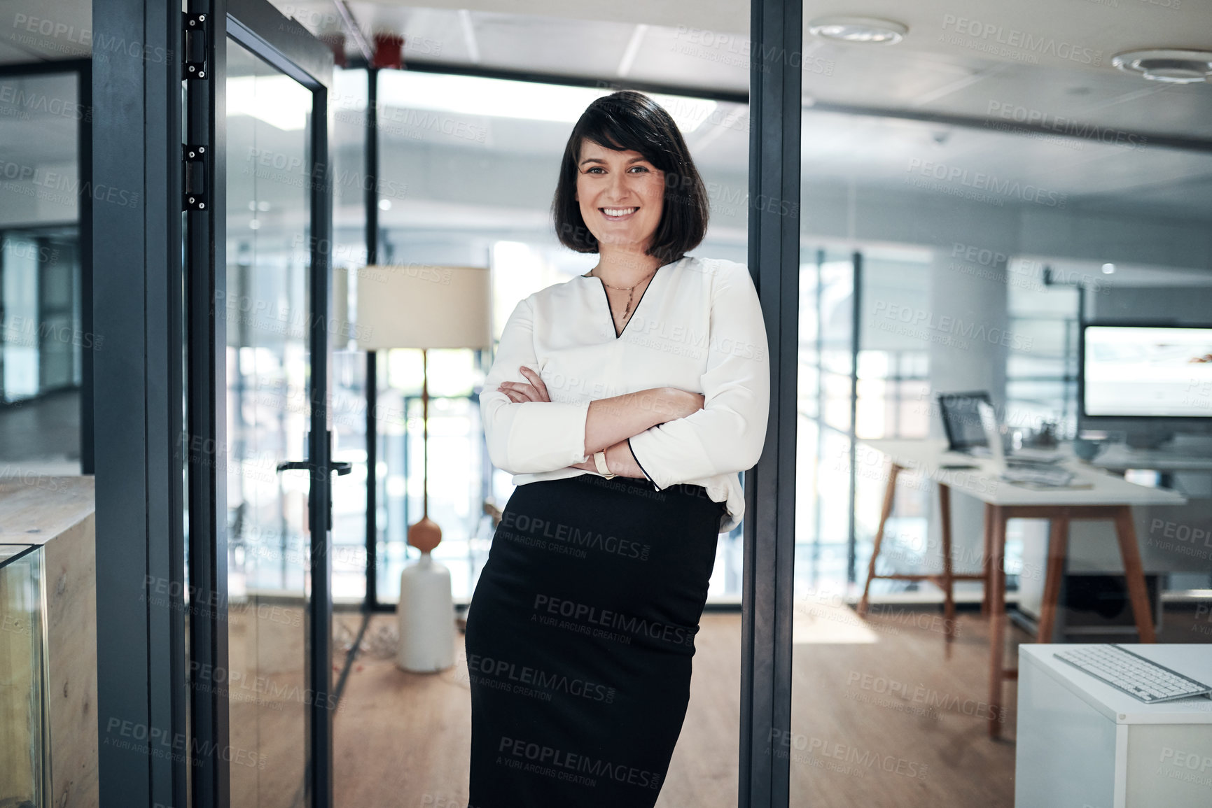 Buy stock photo Cropped shot of an attractive pregnant businesswoman standing alone in her office with her arms folded