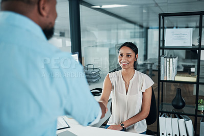 Buy stock photo Cropped shot of an attractive young businesswoman sitting and shaking hands with a colleague in the office