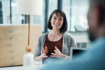 Buy stock photo Cropped shot of two young businesspeople sitting in the office together and having a discussion