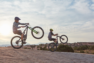 Buy stock photo Full length shot of two men out mountain biking together during the day