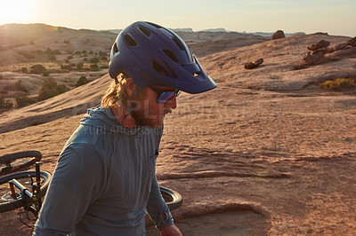 Buy stock photo Cropped shot of a young male athlete mountain biking in the wilderness