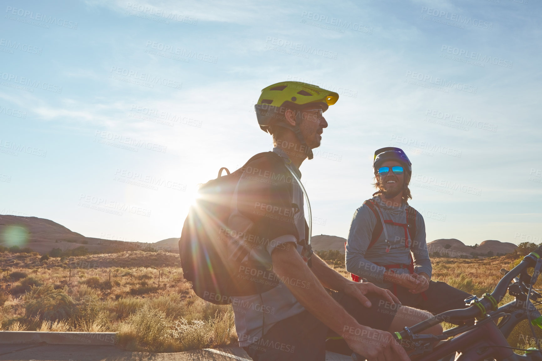 Buy stock photo Cropped shot of two young male athletes mountain biking in the wilderness