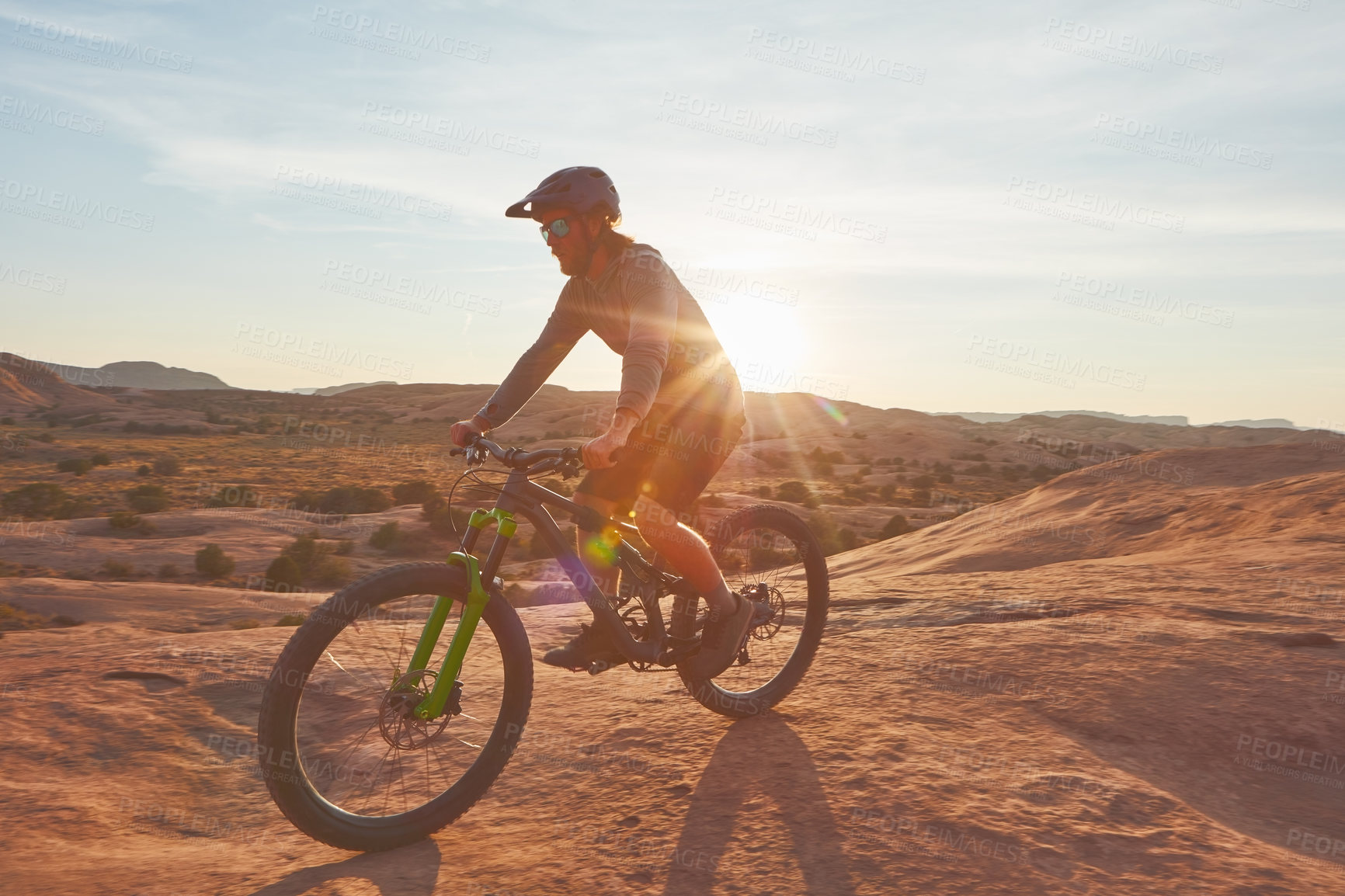 Buy stock photo Full length shot of a young male athlete mountain biking in the wilderness