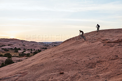 Buy stock photo Full length shot of two men out mountain biking together during the day