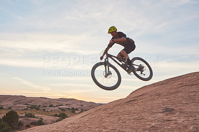 Buy stock photo Shot of a young man out mountain biking during the day