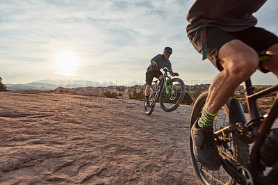 Buy stock photo Shot of two men out mountain biking together during the day