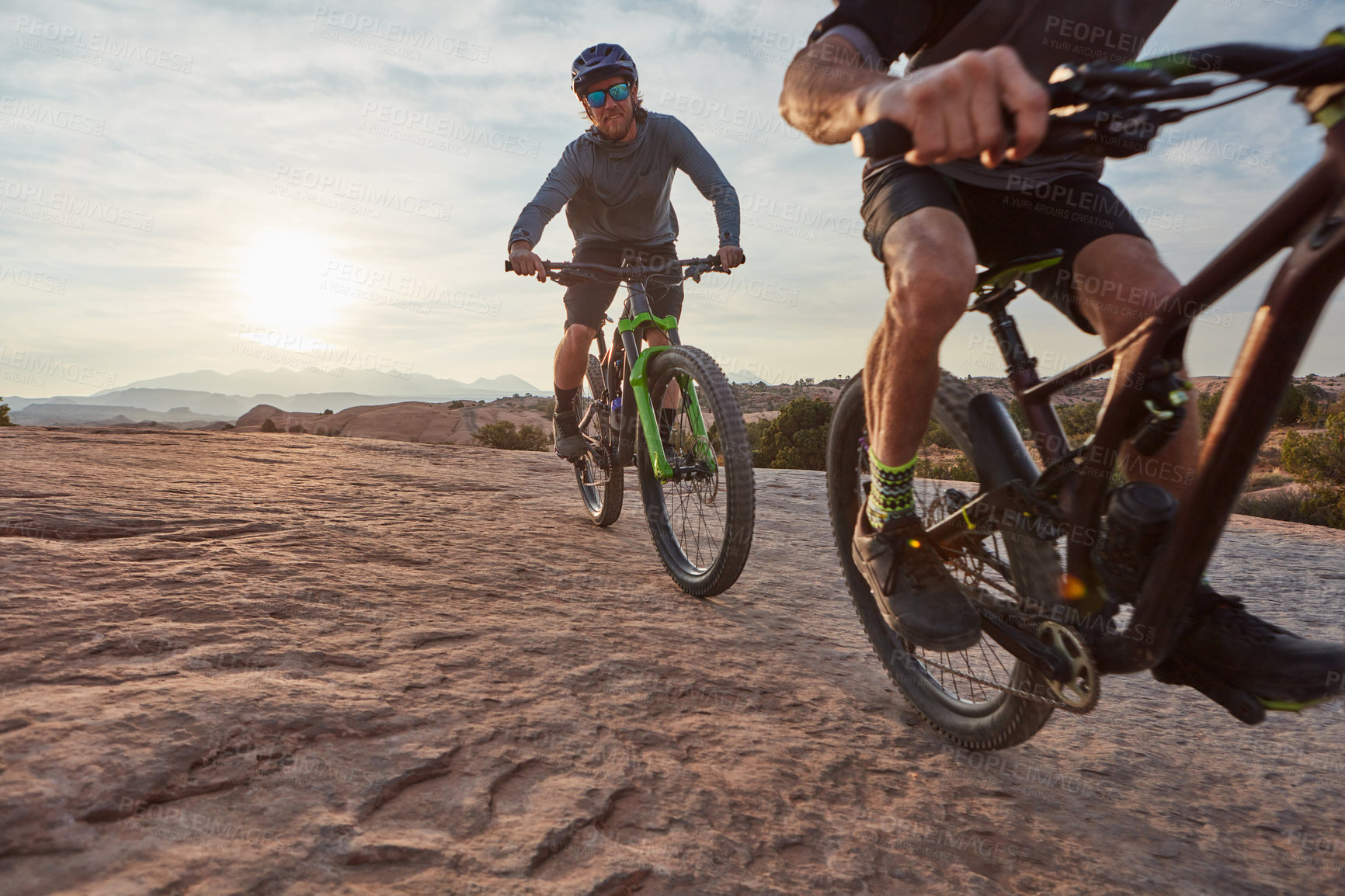 Buy stock photo Shot of two men out mountain biking together during the day