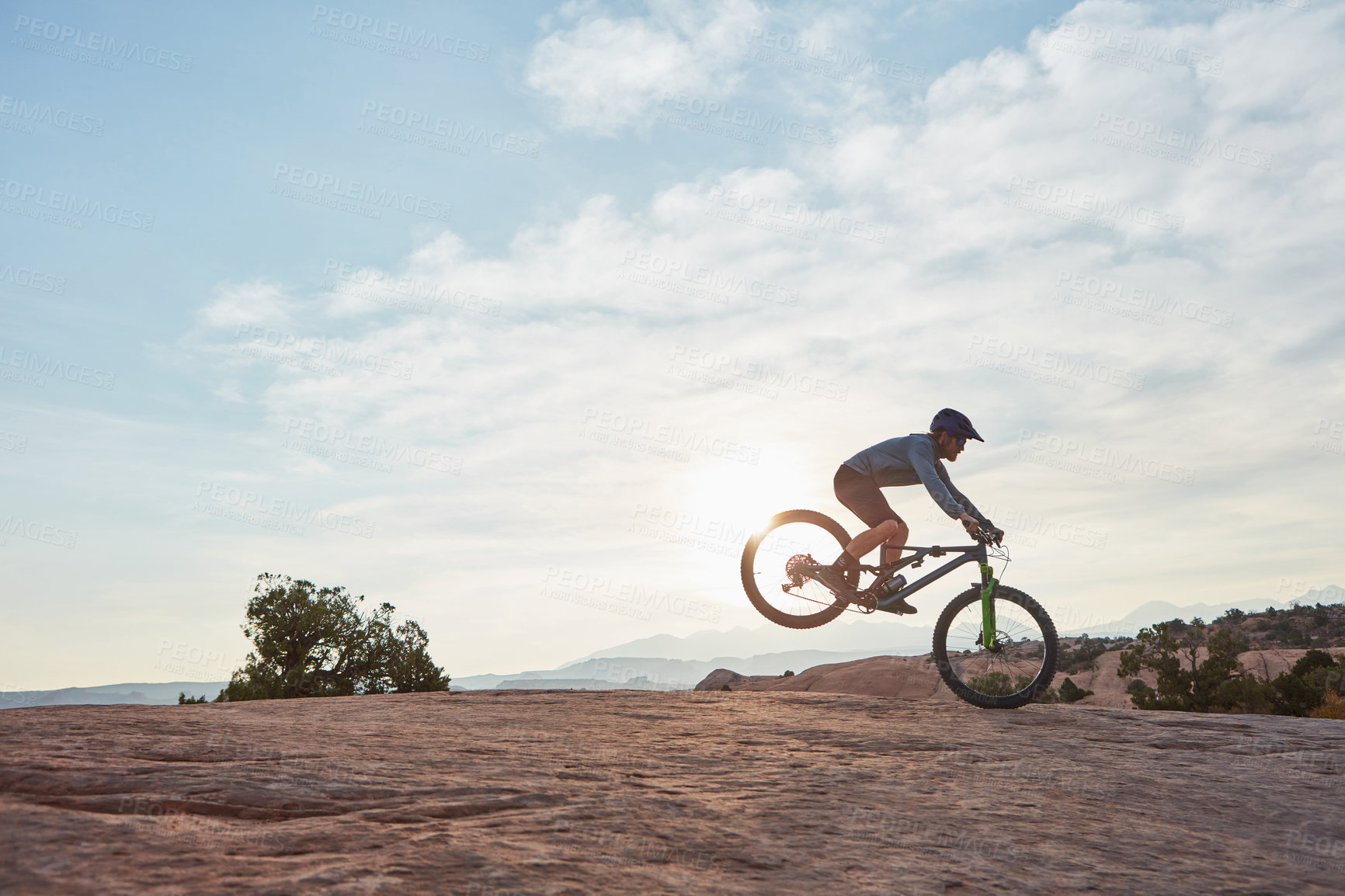 Buy stock photo Shot of a young man out mountain biking during the day