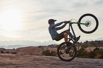 Buy stock photo Shot of a young man out mountain biking during the day