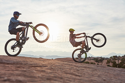 Buy stock photo Full length shot of two men out mountain biking together during the day